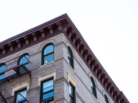 A bracketed cornice along the top of a brick building