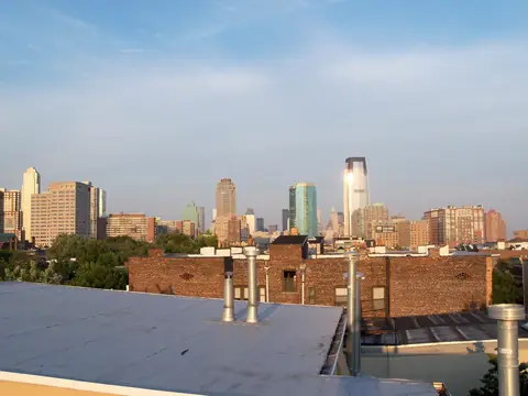 A flat roof in Downtown Jersey City with brick buildings and towers beyond