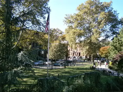Van Vorst Park in Jersey City, with rowhouses beyond the trees