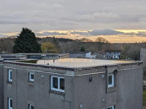 Rainwater ponding on a flat roof near its edge