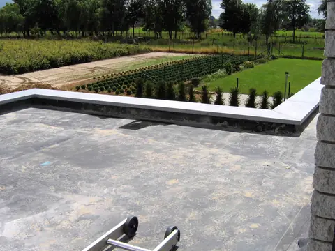 A rubber membrane flat roof running up to a low parapet edge