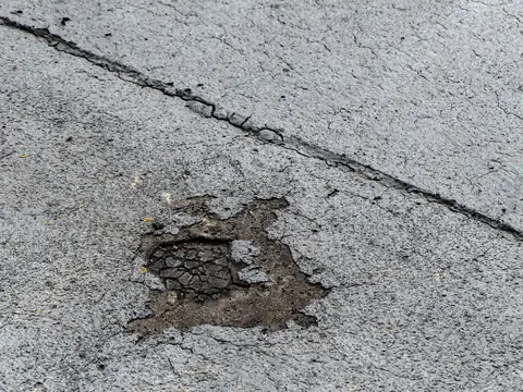 A worn-through spot in an aging bitumen flat roof